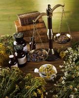 libro y medicina herbal sobre fondo de mesa de madera foto