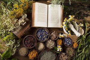 libro y medicina herbal sobre fondo de mesa de madera foto