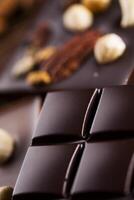 Dark homemade chocolate bars and cocoa pod on wooden photo