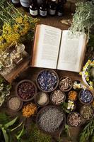 Book and Herbal medicine on wooden table background photo