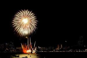 Many flashing fireworks with night cityscape background celebrate New Year. photo