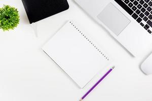 Top view laptop with open display screen monitor, diary and mouse and notepad, glasses and pencil isolated on white background, notebook or netbook with keyboard, communication technology concept. photo