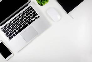 Top view of laptop computer with open display screen monitor, mouse and notepad and book and smart mobile phone isolated on white background, communication technology on work office concept. photo