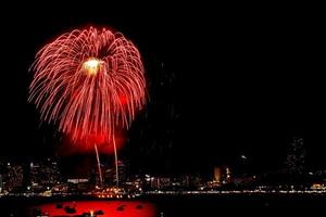 Many flashing fireworks with night cityscape background celebrate New Year. photo