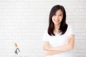 Portrait of beautiful young asian woman happiness standing on gray cement texture grunge wall brick background, businesswoman is a smiling on concrete, business people concept. photo