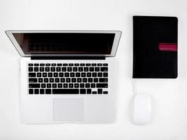 Top view of laptop computer with open display screen monitor, mouse and book isolated on white background, notebook or netbook with keyboard, communication technology concept. photo