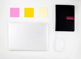 Top view of laptop computer with open display screen monitor, mouse and notepad and note isolated on white background, communication technology concept. photo