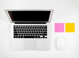 Top view of laptop computer with open display screen monitor, mouse and notepad isolated on white background, notebook or netbook with keyboard, communication technology concept. photo
