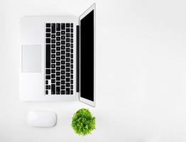 Top view of laptop computer with open display screen monitor, diary and mouse isolated on white background, notebook or netbook, communication technology on work office concept. photo