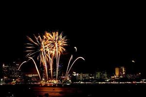Many flashing fireworks with night cityscape background celebrate New Year. photo