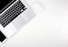 Top view of laptop computer with open display screen monitor, mouse and smart mobile phone isolated on white background, communication technology on work office concept. photo