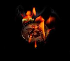 The gold bitcoin is on fire at a black background photo