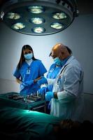 un profesor de medicina está enseñando cirugía a estudiantes de medicina que trabajan foto