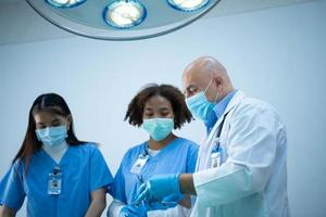 A medical professor is teaching surgery to medical students working photo