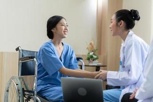 Two female doctors at an international hospital giving advice to convalescent patients photo