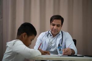 un médico en un hospital internacional tratando de controlar a un niño travieso foto