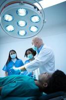 A medical professor is teaching surgery to medical students working photo