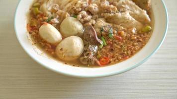 Nudeln mit Schweinefleisch und Frikadellen in scharfer Suppe oder Tom Yum Nudeln nach asiatischer Art