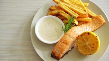 Pescado frito con salmón y patatas fritas con limón en el plato video