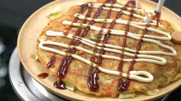 poner salsa en okonomiyaki o pizza japonesa