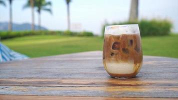 iced latte coffee glass on wood table video