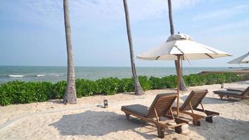 Parasol avec chaise de plage et fond de mer océan - concept de vacances et de vacances