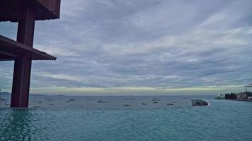 swimming pool with ocean sea and boat and cloudy sky background
