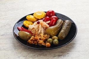 Plate with pickled vegetables and mushrooms photo