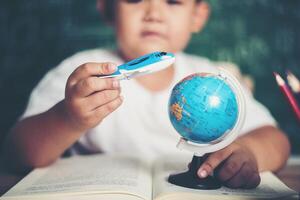 Portrait of boy with a plane model in classroom photo