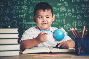 Portrait of boy with a plane model in classroom photo