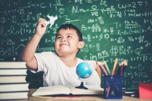 retrato de niño con un modelo de avión en el aula foto