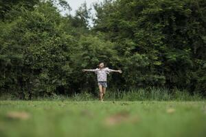 feliz linda niña corriendo sobre la hierba en el parque foto