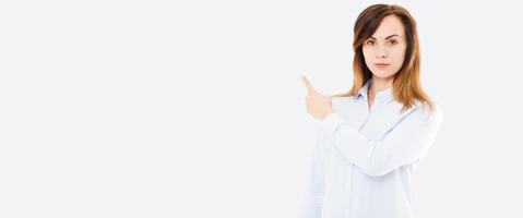 Photo of happy young woman standing isolated over white background. Looking camera showing copyspace pointing. Mock up, hand point