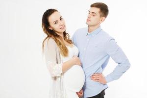 Smiling pregnant young couple hugging while standing together photo