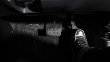 Accelerate and Brake. Foot pressing foot pedal of a car to drive ahead. photo