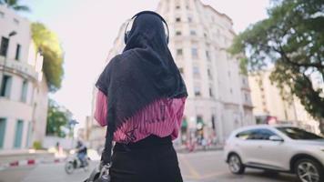 joven turista musulmana usa hiyab tomando fotos en un hermoso edificio arquitectónico emblemático, la atracción debe ver el lugar, el estilo de vida y los viajes, compartiendo experiencias contando historias, vista trasera video