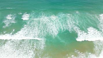 Zoom in aerial view of sand beach and water surface texture. Foamy waves with sky. Beautiful tropical beach. Amazing Sandy coastline with white sea waves. Nature, seascape and summer concept. video