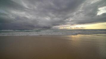 plage de sable de l'océan bleu et texture de la surface de l'eau. vagues mousseuses avec ciel. belle plage tropicale. incroyable littoral sablonneux avec des vagues de mer blanche. nature, paysage marin et concept d'été. video