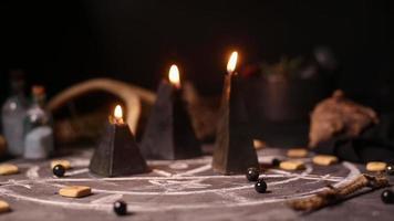 les bougies magiques noires brûlent. fumée sur fond des attributs magiques de l'art noir. notion d'Halloween.