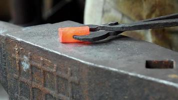 Man hitting a red metal. Making a blade of a knife in Black smith video