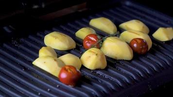 patate e pomodori deliziosi caldi fritti sulla griglia elettrica video