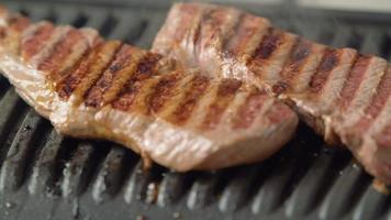 Heißes köstliches Beefsteak, das auf dem Elektrogrill zubereitet wird video