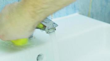 Man cleaning faucet with the rag in bathroom. 4k video footage