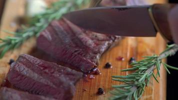 Hot delicious beefsteak cutting on a wood cutting board with a knife