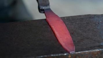 Mann, der ein rotes Metall schlägt. Herstellung einer Messerklinge im Schmied video