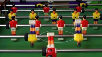 pessoas jogando futebol de mesa com figuras de plástico fofas vermelhas e amarelas. imagens de vídeo 4k