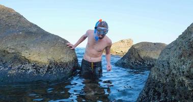 jonge mannelijke zwemmer met snorkelbril duikt in de zomerzee video