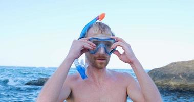 joven nadador masculino con gafas de buceo bucear en el mar de verano