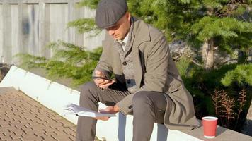 jovem macho ler livro ao ar livre na rua video