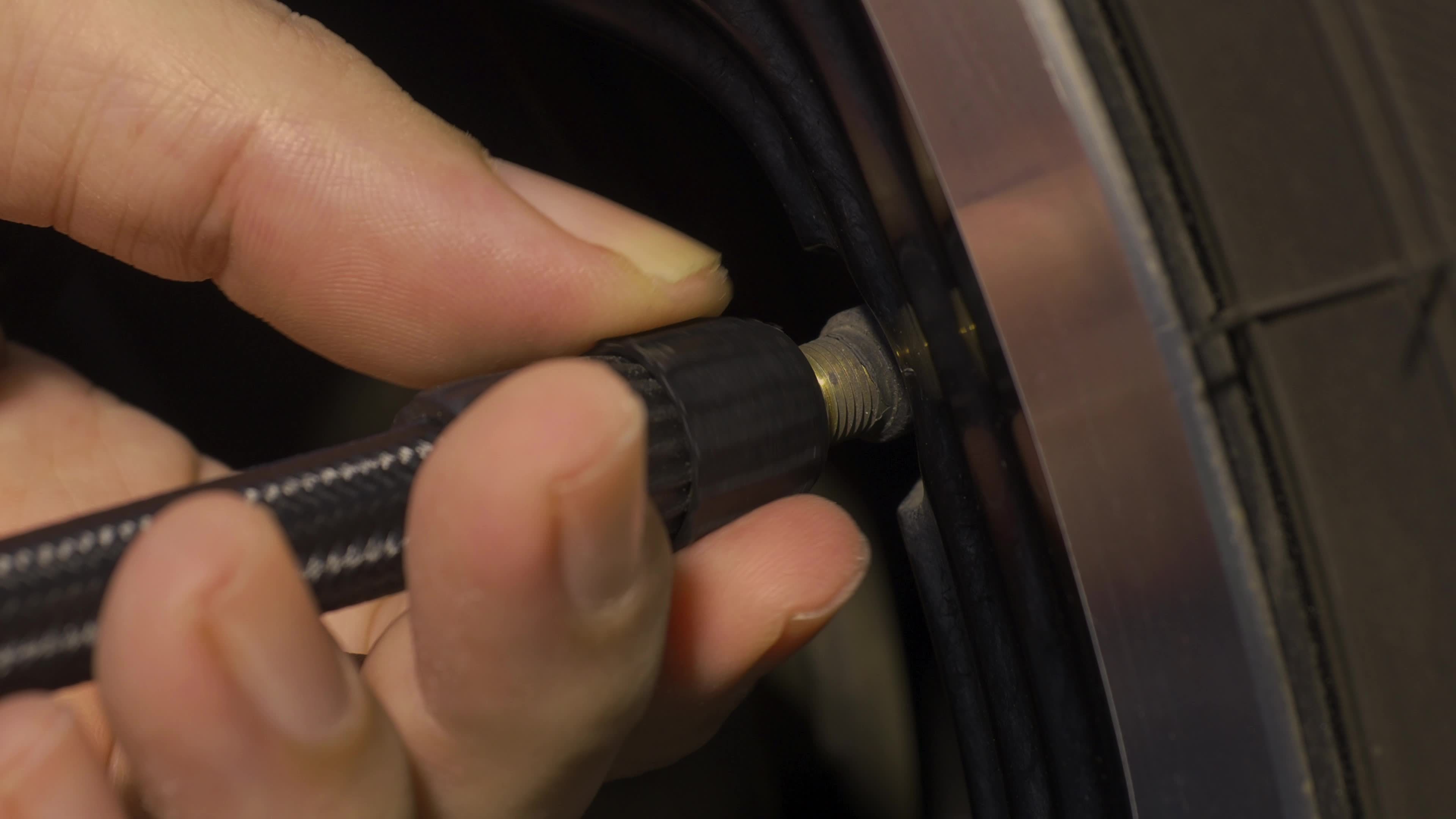 Inflating tire. man hand open valve cap and inflate car tyre before